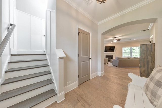 4230 Old Cherokee St, Acworth, GA 30101 - staircase featuring ceiling fan, ornamental molding, wood finished floors, a fireplace, and arched walkways