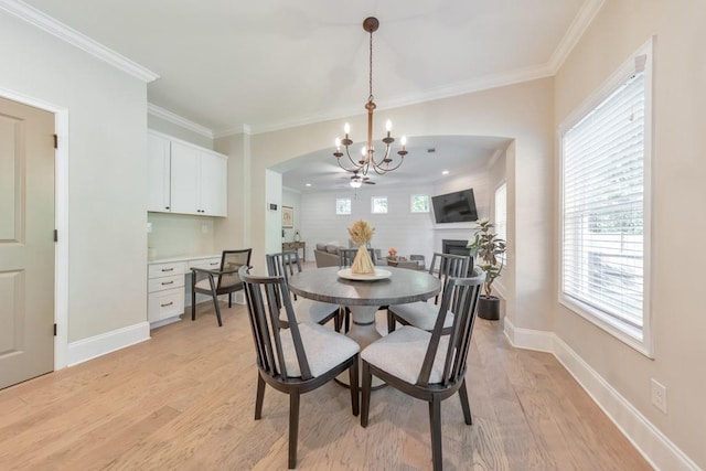4230 Old Cherokee St, Acworth, GA 30101 - dining room featuring a chandelier, light wood-style floors, crown molding, arched walkways, and a fireplace