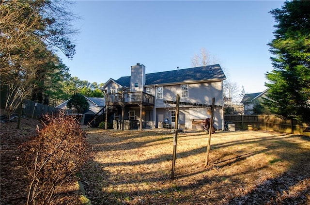 back of house with a lawn, a fenced backyard, a chimney, a wooden deck, and a pergola