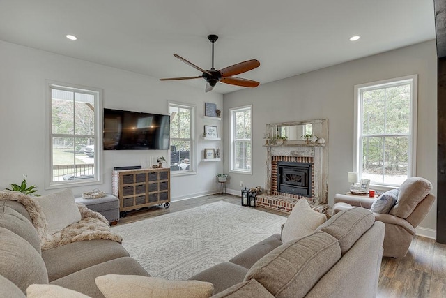 living room featuring wood-type flooring, a healthy amount of sunlight, and ceiling fan