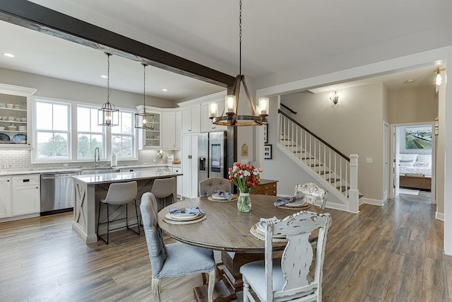 dining space featuring dark hardwood / wood-style floors, sink, and beam ceiling