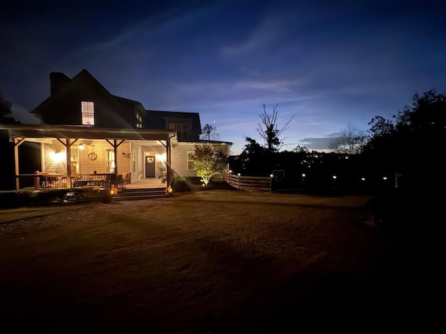 back house at dusk with covered porch