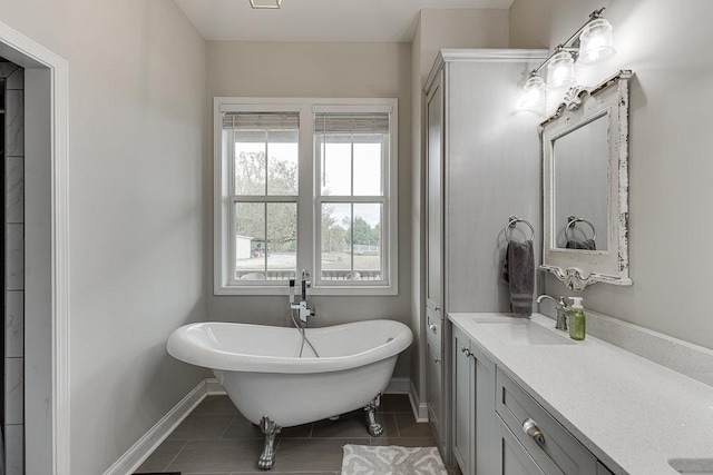 bathroom with tile patterned flooring, a washtub, and vanity