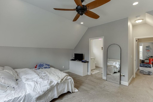 carpeted bedroom with ensuite bath, ceiling fan, and vaulted ceiling