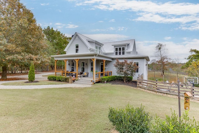 country-style home featuring covered porch and a front yard