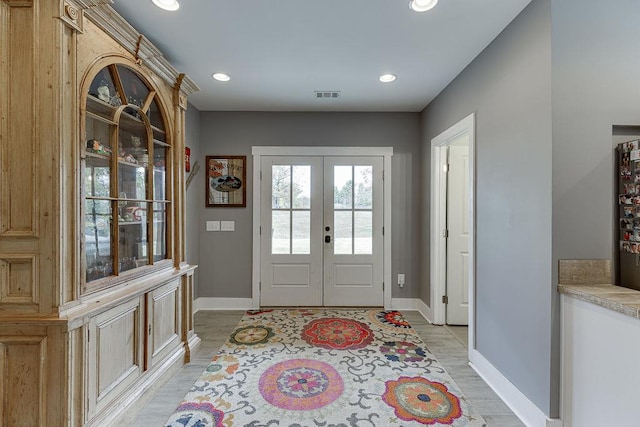 foyer entrance featuring french doors and light wood-type flooring