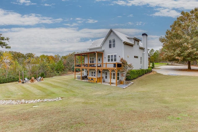 rear view of house with a lawn and a patio area