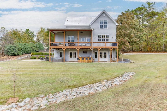 rear view of property with a patio, a yard, french doors, and ceiling fan