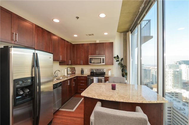 kitchen featuring a wealth of natural light, a center island, sink, stainless steel appliances, and dark hardwood / wood-style floors