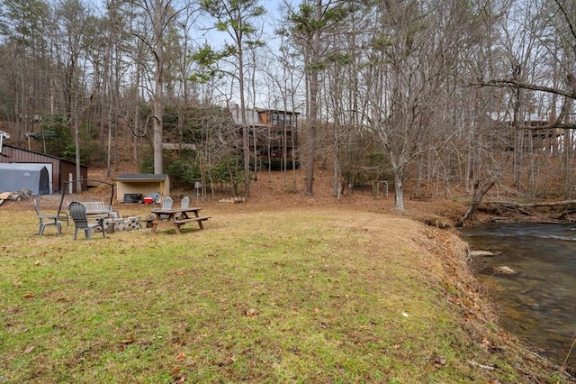 view of yard featuring an outbuilding and a water view