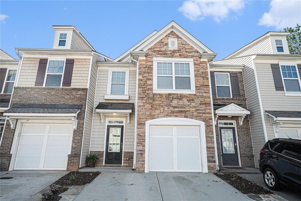 1954 Durwood Ln, Duluth, GA 30096 - townhome / multi-family property featuring stone siding, driveway, and a garage
