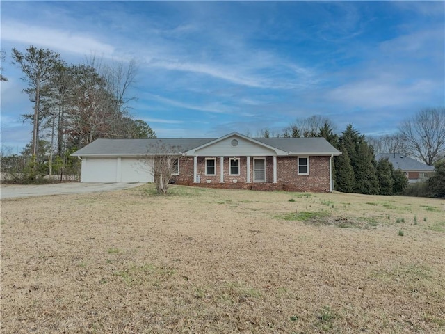 view of front of property with a front yard, concrete driveway, brick siding, and an attached garage