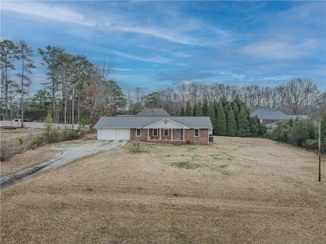 ranch-style home with driveway, brick siding, an attached garage, fence, and a front yard