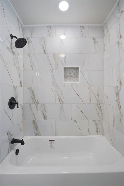 bathroom featuring crown molding and tiled shower / bath