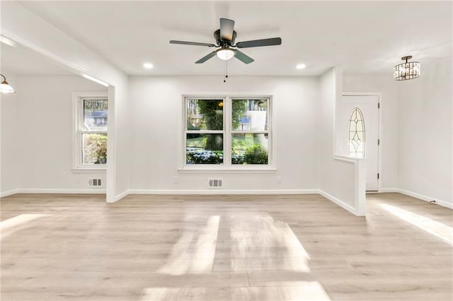 interior space with light hardwood / wood-style floors and ceiling fan with notable chandelier