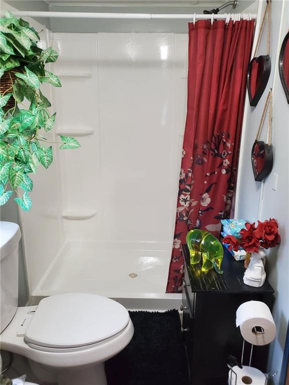 bathroom featuring toilet and a shower with shower curtain