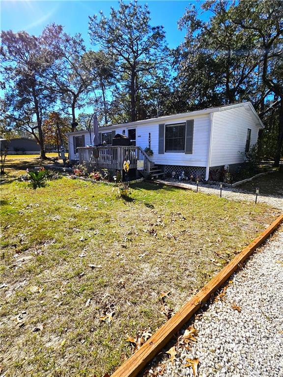 view of front of property featuring a wooden deck and a front lawn