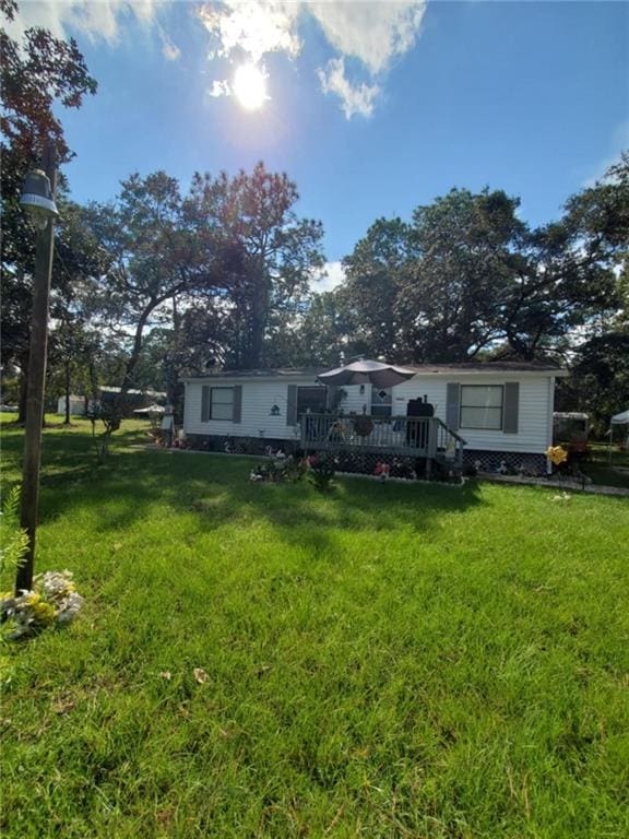 back of house with a wooden deck and a lawn