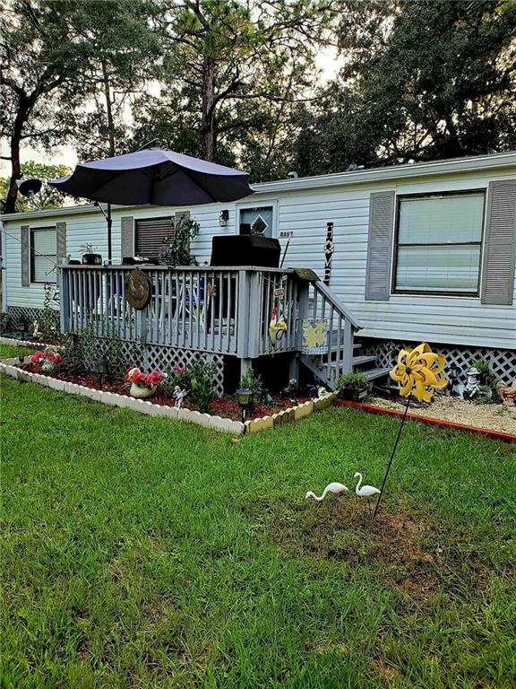 back of house featuring a yard and a deck