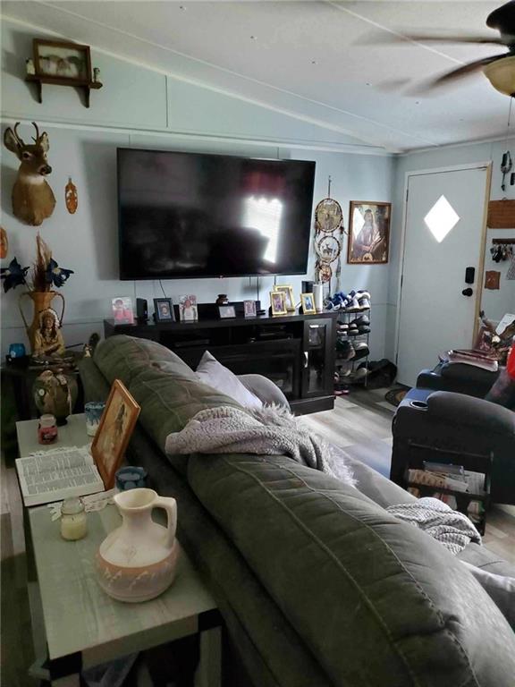 living room featuring lofted ceiling, hardwood / wood-style floors, and ceiling fan