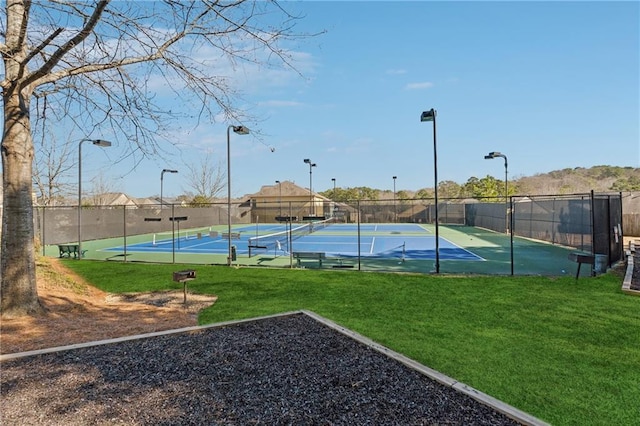 view of basketball court with a yard, fence, and a tennis court