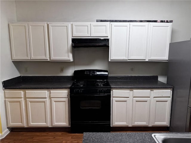 kitchen featuring gas stove, stainless steel refrigerator, white cabinets, and exhaust hood