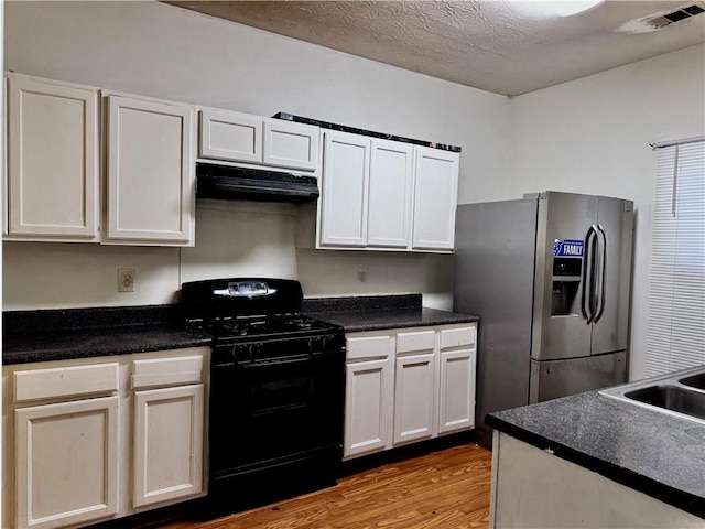 kitchen with white cabinetry, stainless steel fridge, black gas stove, light hardwood / wood-style floors, and a textured ceiling