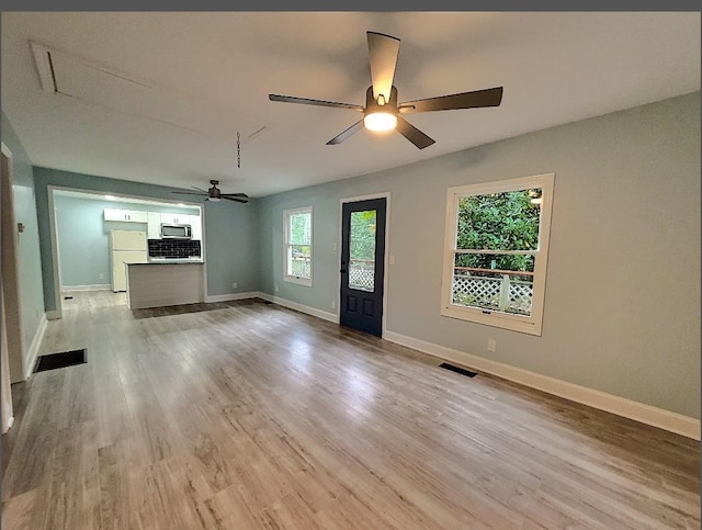 unfurnished living room featuring ceiling fan, light hardwood / wood-style floors, and plenty of natural light