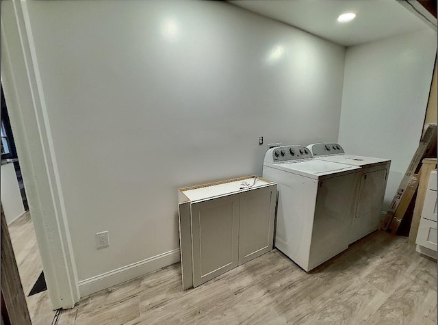 clothes washing area featuring washing machine and dryer and light wood-type flooring