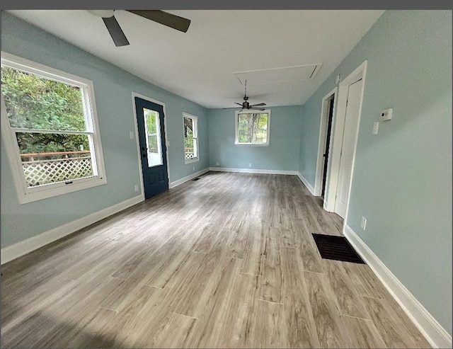 unfurnished dining area with ceiling fan, a healthy amount of sunlight, and light hardwood / wood-style floors