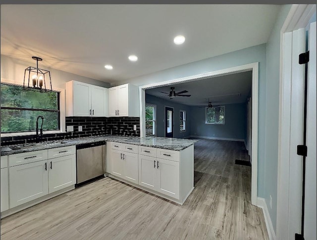 kitchen with ceiling fan with notable chandelier, white cabinets, dishwasher, light hardwood / wood-style floors, and sink