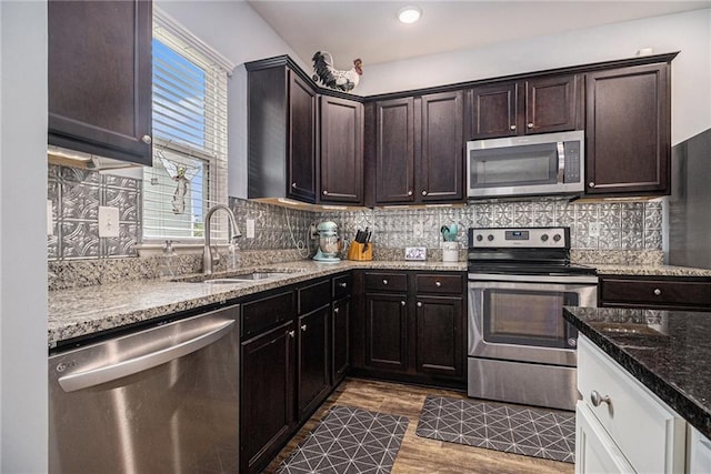 23 Stable Gate Dr, Cartersville, GA 30120 - kitchen with stainless steel appliances, light stone counters, dark brown cabinetry, decorative backsplash, and dark wood finished floors