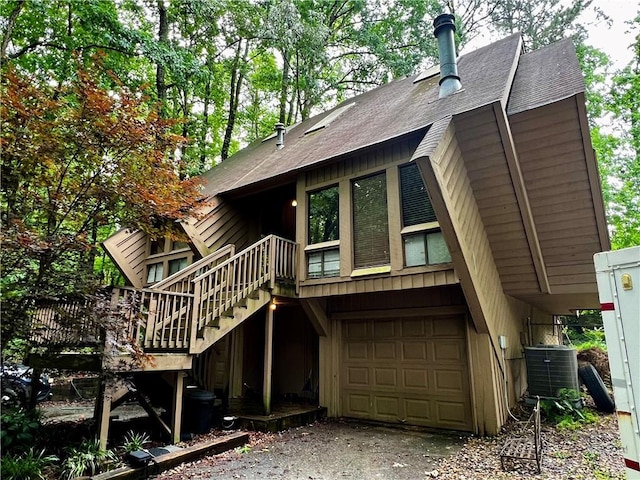 2965 Pond View Ct, Marietta, GA 30062 - back of property with central AC, an attached garage, stairway, a shingled roof, and driveway