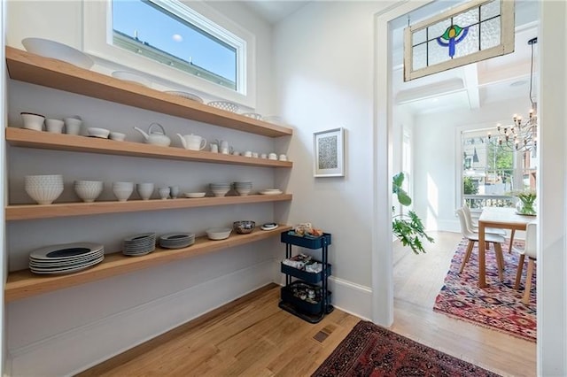 1601 Marlbrook Dr NE, Atlanta, GA 30307 - hallway featuring healthy amount of natural light, wood finished floors, a chandelier, beam ceiling, and baseboards