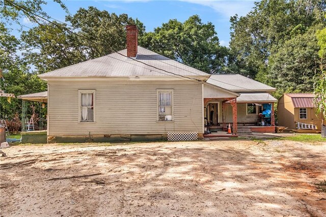 rear view of property featuring an outdoor structure