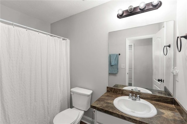 bathroom featuring toilet, vanity, and a textured ceiling