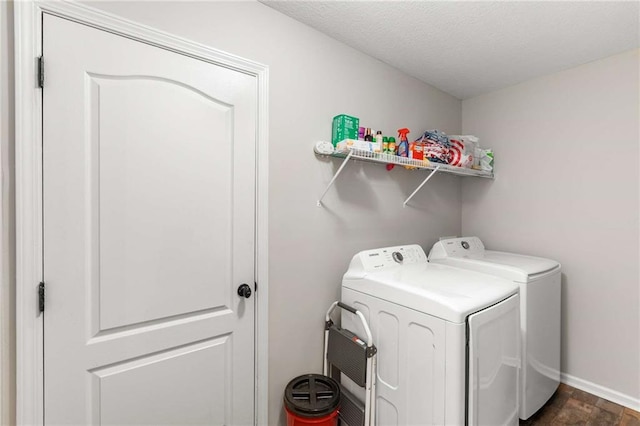 laundry room with baseboards, a textured ceiling, laundry area, and washing machine and clothes dryer