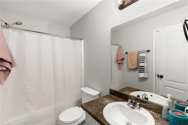 full bathroom with curtained shower, toilet, vanity, and a textured ceiling