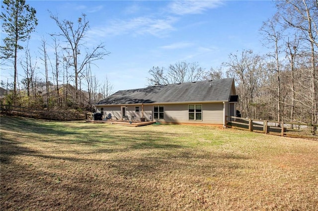 back of property featuring a wooden deck, a yard, and fence