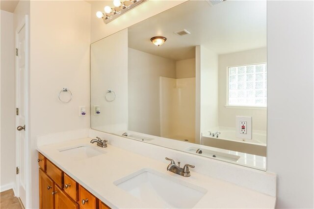 bathroom with tile patterned floors, a bathing tub, and vanity