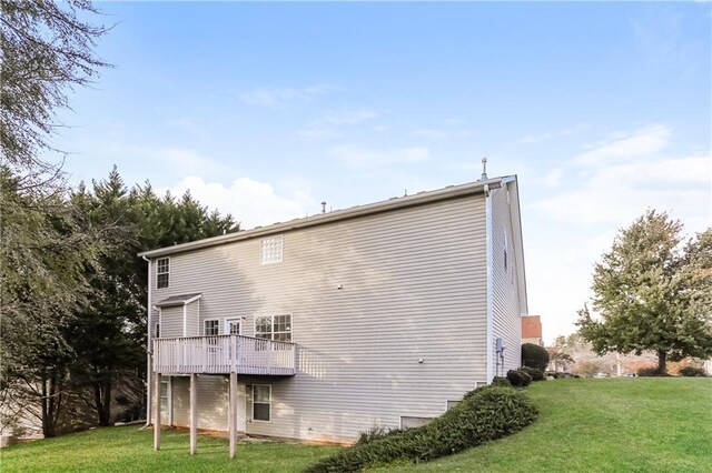 rear view of property featuring a lawn