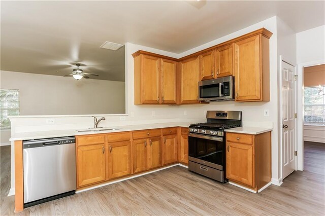 kitchen with ceiling fan, light hardwood / wood-style floors, sink, and appliances with stainless steel finishes