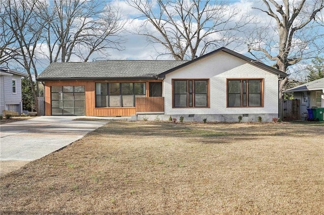 view of front of home with driveway, brick siding, crawl space, and a front yard