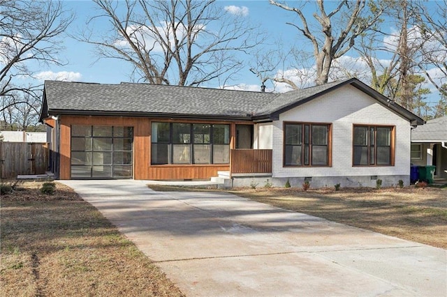 view of front of property featuring a shingled roof, crawl space, brick siding, and driveway