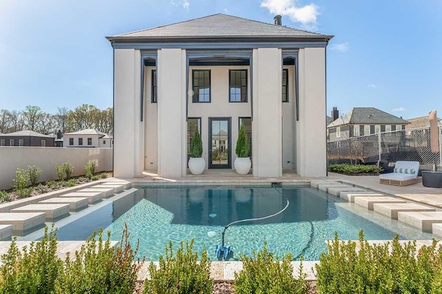 back of house featuring an outbuilding and a fenced in pool