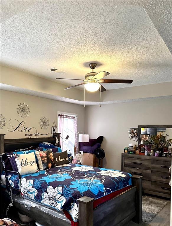 6030 Creekside Dr, Columbus, GA 31907 - bedroom with a ceiling fan, a textured ceiling, and visible vents