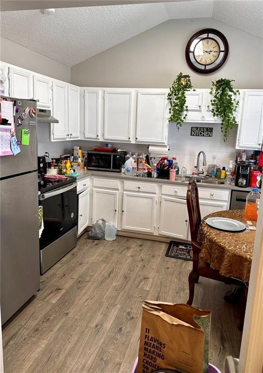 6030 Creekside Dr, Columbus, GA 31907 - kitchen with a sink, appliances with stainless steel finishes, vaulted ceiling, and white cabinetry