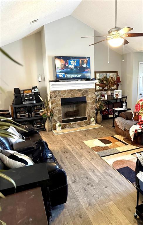 6030 Creekside Dr, Columbus, GA 31907 - living area with a stone fireplace, a ceiling fan, wood finished floors, lofted ceiling, and visible vents
