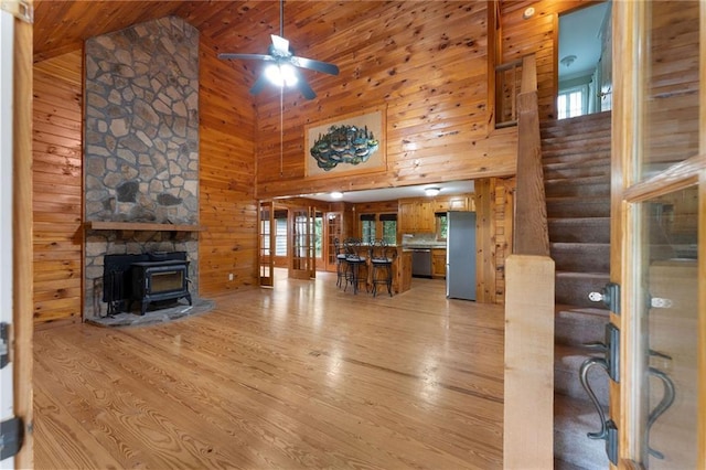 442 Cartecay River Run, Ellijay, GA 30536 - living area with high vaulted ceiling, light wood-style flooring, wooden walls, ceiling fan, and a wood stove