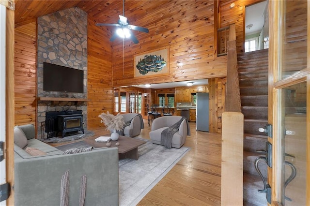 442 Cartecay River Run, Ellijay, GA 30536 - living area featuring high vaulted ceiling, a wood stove, wood walls, light wood-type flooring, and ceiling fan
